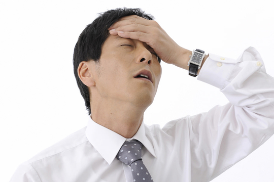 額に手を当てる男性