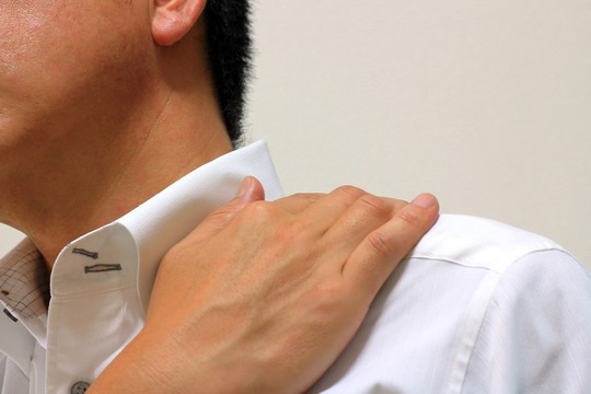 肩に手を当てる男性