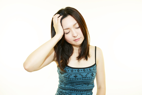 頭を押さえる女性