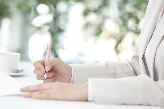 ペンを持つ女性の手元