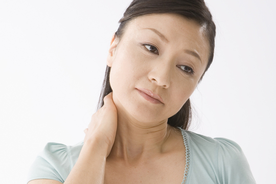 首に手を当てる女性