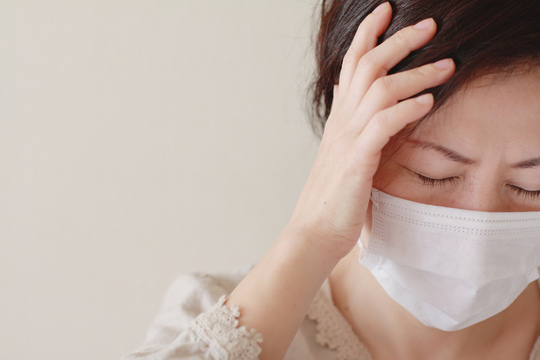 頭を押さえる女性