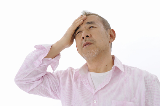 額に手を当てる男性